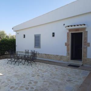 a white building with chairs and tables in front of it at Villa Anna Buonvino in Giovinazzo