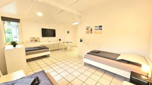 una grande camera con due letti e una TV di 1 room apartment with 3 beds and terrace (ALT03) ad Altena