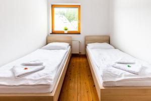 2 Betten in einem kleinen Zimmer mit Fenster in der Unterkunft Horská chata Harrachov in Harrachov