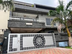 a house with a white gate and a balcony at Luxury Holiday Home in Islamabad in Islamabad