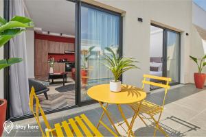 a living room with a yellow table and chairs at Stayhere Rabat - Agdal 4 - Hotel in Rabat