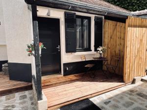 a wooden deck with a table and a window at Appartement standing à 7min de Fontainebleau centre, 3min de Moret-sur-Loing et 45min de Paris (1min à pied de la gare) in Veneux-les-Sablons