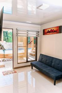 een woonkamer met een zwarte bank en een glazen schuifdeur bij 2 Cabañas para 5 Personas Oasis Pica-Matilla in Pica