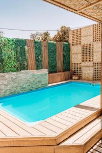 a swimming pool with a wooden deck and a swimming poolvisor at 2 Cabañas para 5 Personas Oasis Pica-Matilla in Pica