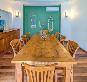 a dining room with a wooden table and chairs at Plumeria Villa in Pointe aux Cannoniers