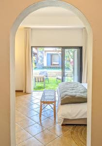 a bedroom with a bed and a view of a patio at Plumeria Villa in Pointe aux Cannoniers