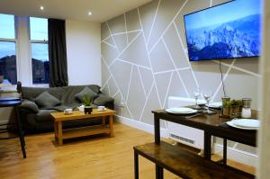 Grace House Apartment - Yorkshire : غرفة معيشة مع أريكة وتلفزيون على الحائط