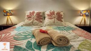 A bed or beds in a room at Ti Kaz Funky Host -T3 vue mer prémium 3 étoiles - Village vacances Sainte Anne Guadeloupe