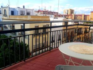 einen Balkon mit einem Tisch und Stadtblick in der Unterkunft La casa de Leon XIII.Terraza Privada. Parejas in Sevilla
