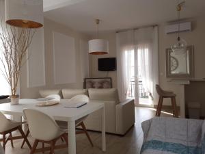 ein Wohnzimmer mit einem weißen Tisch und einem Sofa in der Unterkunft La casa de Leon XIII.Terraza Privada. Parejas in Sevilla