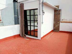ein leeres Zimmer mit einer Tür und einem roten Boden in der Unterkunft La casa de Leon XIII.Terraza Privada. Parejas in Sevilla