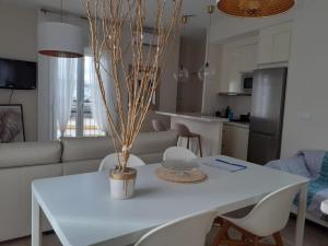 einen weißen Esstisch mit Stühlen und eine Küche in der Unterkunft La casa de Leon XIII.Terraza Privada. Parejas in Sevilla