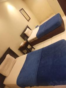 two beds in a hotel room with blue pillows at سلسبيل للغرف المفروشة in Al Khobar