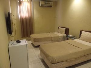 a hotel room with two beds and a television at سلسبيل للغرف المفروشة in Al Khobar