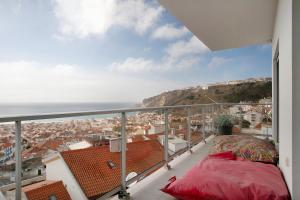 a balcony with a view of a city and the ocean at Sea view - dream Nazaré in Nazaré