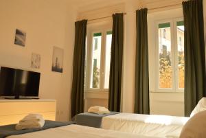 1 dormitorio con 2 camas, TV y ventana en Civico 37 Casa Vacanze Porta Romana, en Milán