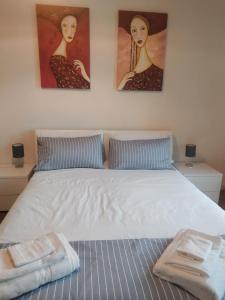 1 dormitorio con 1 cama con 2 cuadros en la pared en Civico 37 Casa Vacanze Porta Romana, en Milán