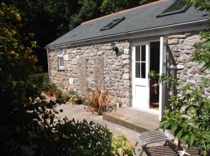 een stenen cottage met een witte deur bij new pottery in Penzance