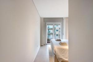 sypialnia z łóżkiem i oknem w obiekcie Póvoa 3 Suites w mieście Póvoa de Varzim