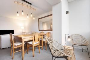 jadalnia z drewnianym stołem i krzesłami w obiekcie Póvoa 3 Suites w mieście Póvoa de Varzim