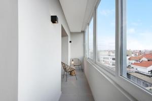 pusty pokój z dużym oknem i krzesłem w obiekcie Póvoa 3 Suites w mieście Póvoa de Varzim