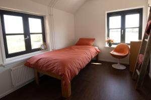 1 dormitorio pequeño con 1 cama y 2 ventanas en Grazelands - overnachten midden in de natuur, 