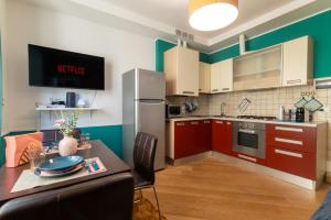 a kitchen with red and green walls and a table and chairs at Jesi Centro Teatro Pergolesi in Iesi +6 photos