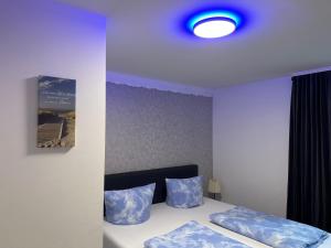 una camera da letto con letto e cuscini blu di Souterrain FeWo, Europapark, Netflix, 2xTV a Mietersheim