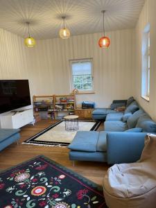 a living room with blue couches and a flat screen tv at "Alte Fabrik" Ferien-und Seminarhaus 