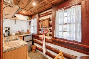 uma cozinha num chalé de madeira com um lavatório e uma janela em Mountain Peace II em Lake Junaluska