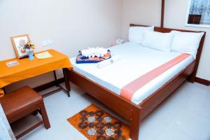 ein kleines Schlafzimmer mit einem Bett und einem Tisch in der Unterkunft Port Park Hotel in Mwanza