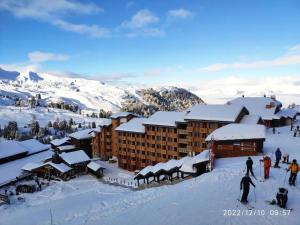 a group of people on skis in the snow near a lodge at Appartement Belle Plagne in La Plagne Tarentaise