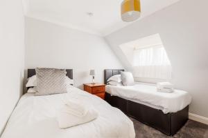 a bedroom with two beds and a window at The Gables Penthouse in Poole