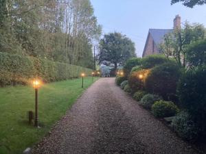a gravel path with street lights in a park at Delightful Cottage with 2 Bedrooms near Knutsford in Knutsford