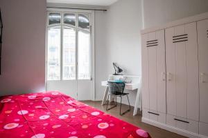 1 dormitorio con cama roja, escritorio y ventana en Maison standing 9 chambres 5SB avec extérieur, en Roubaix