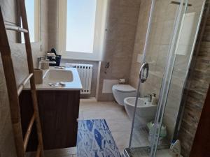 een badkamer met een douche, een wastafel en een toilet bij Casa Rosetta in Lecce