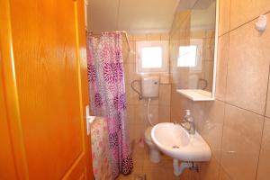 a bathroom with a sink and a shower curtain at Apartments Stevan in Bar