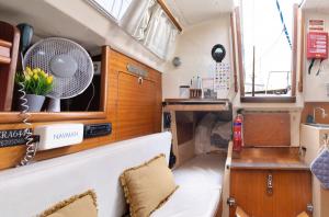ein kleines Zimmer in einem Boot mit einem Ventilator in der Unterkunft Happy Sailor in Viana do Castelo