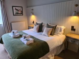 a bedroom with a bed with towels on it at Priory Inn in Tetbury