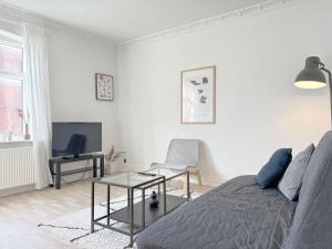 - un salon blanc avec un lit et une télévision dans l'établissement Perfect Apartment For Travelers On A Budget - But Still Wants Quality, à Randers