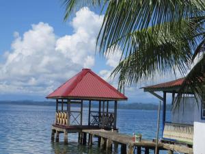 a gazebo on the water next to a dock at Caribbean Villages Aparments in Bocas del Toro
