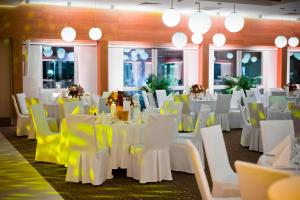 un salón de banquetes con mesas blancas y sillas amarillas en Hotel Platan en Gdansk