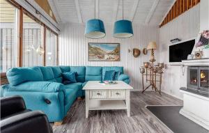 a living room with a blue couch and a table at Cozy Home In Sikns With House Sea View 