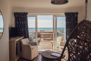 a living room with a view of the ocean at The Beach Box By Air Premier in Seaford