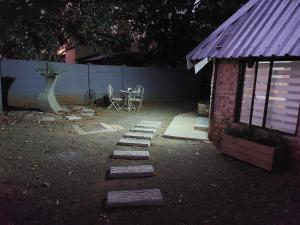 un cortile con tavolo, sedie e un edificio di The Spare Room Cottage - cosy and private a Bloemfontein