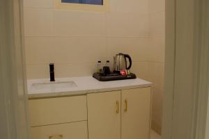 eine Küche mit einer Spüle und einem Mixer auf der Theke in der Unterkunft Arica hotel apartments in Tabuk