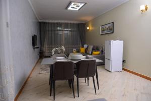 d'une salle à manger avec une table et un réfrigérateur blanc. dans l'établissement 2 Bedroom Suite In 3 Bedroom Apartment, à Namulanda