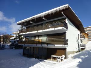 ラルプ・デュエズにあるAppartement Huez, 1 pièce, 4 personnes - FR-1-405-67の雪の中のバルコニー付きの建物