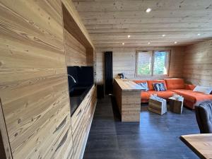 salon z pomarańczową kanapą w drewnianym pokoju w obiekcie Appartement Méribel, 4 pièces, 8 personnes - FR-1-180-173 w Méribel