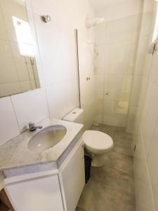 a white bathroom with a toilet and a sink at AP ap aps in São João del Rei